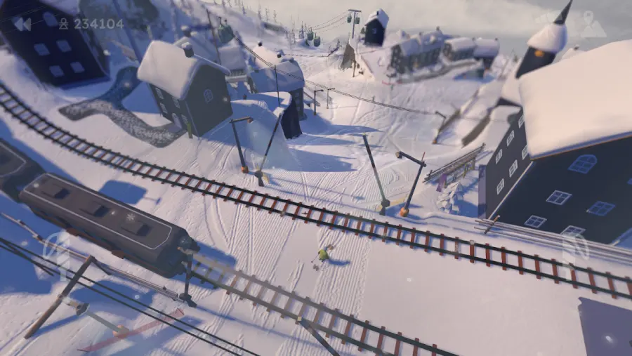 Schermata di Grand Mountain Adventure 2: uno sciatore scende fuori pista su neve battuta accanto ai binari di una ferrovia di montagna, senza porte ne percorso segnato.